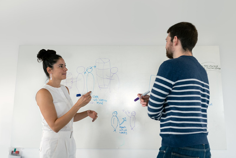 Photograph of two engineers by whiteboard